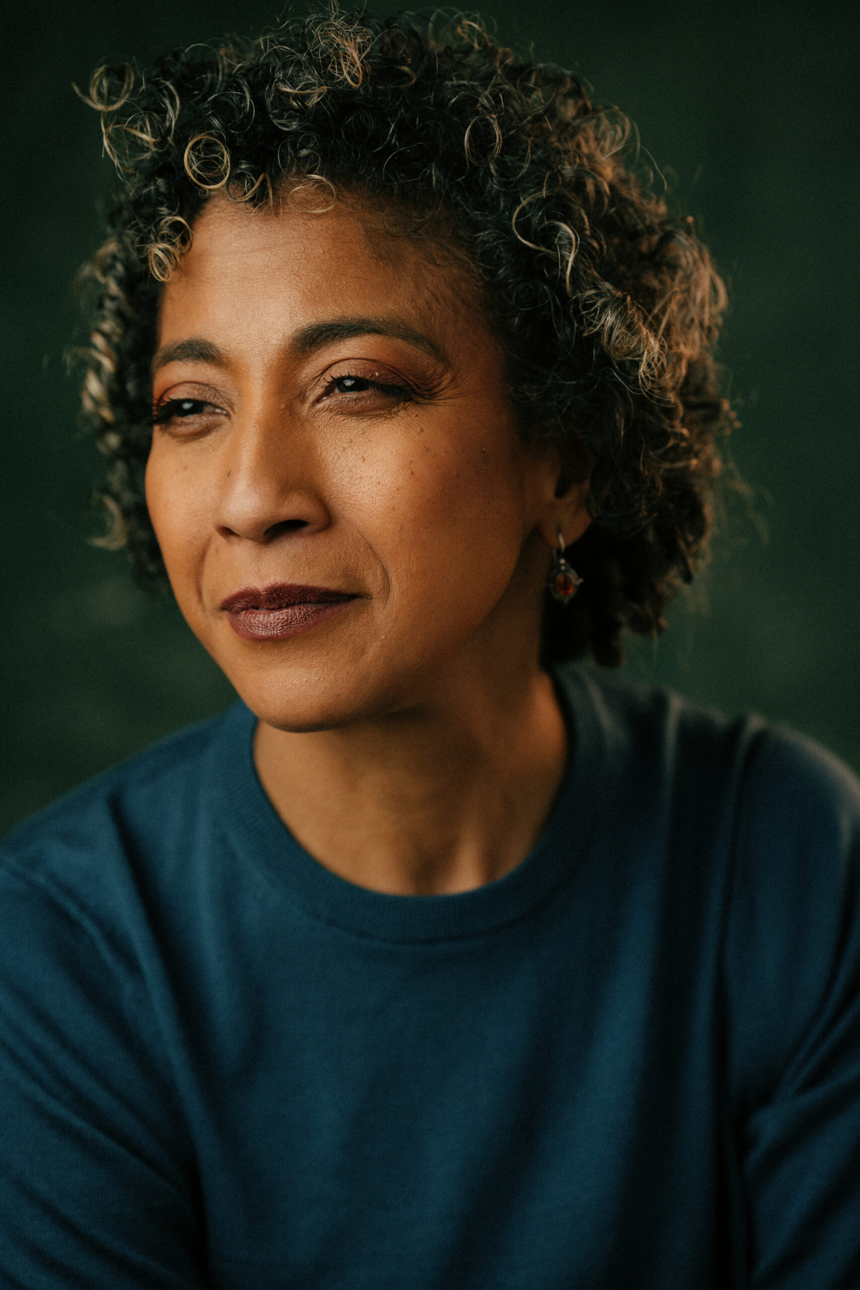 Bio page Mel in a blue top looking towards the left